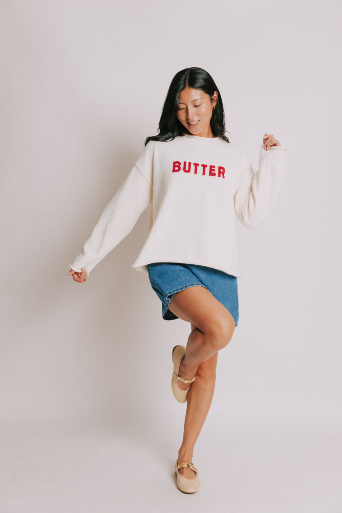 cream sweater with rolled edges and butter emblem full