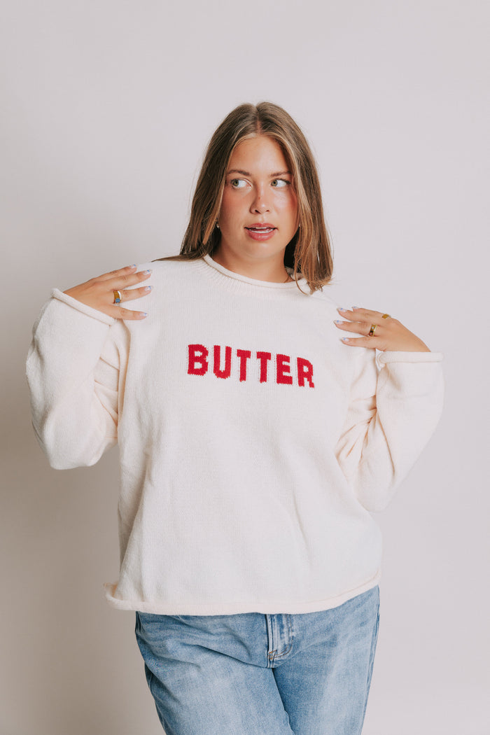 cream sweater with rolled edges and butter emblem plus