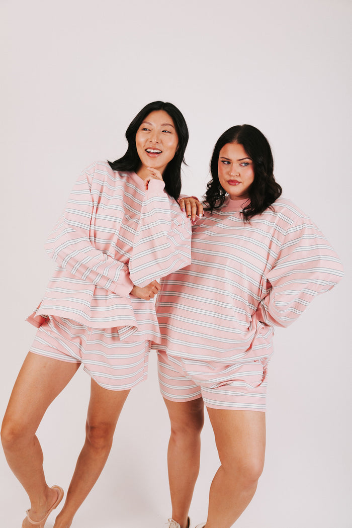pink and white striped lounge shorts models pose