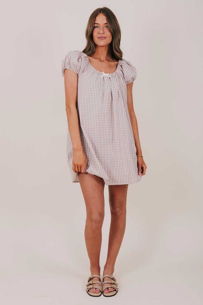 white and tan gingham dress with round neckline, bubble sleeves, and a bow detail. Mini-knee length tent dress gathered details