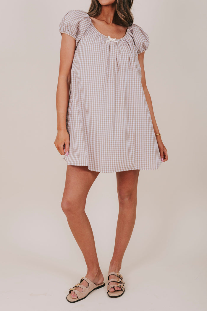 white and tan gingham dress with round neckline, bubble sleeves, and a bow detail. Mini-knee length tent dress gathered details