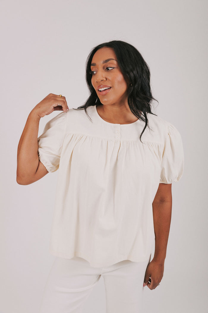 ivory colored blouse with short puff sleeves and gathered detail