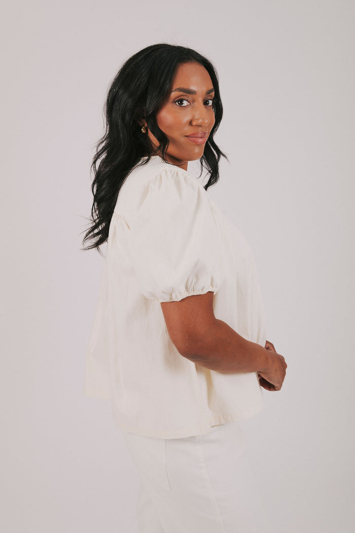 ivory colored blouse with short puff sleeves and gathered detail