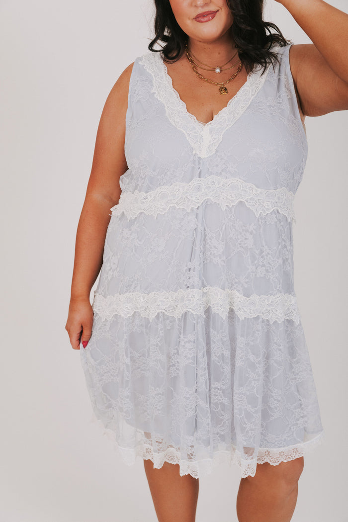 Blue dress with lace overlay and contrast lace trim. V-neckline, sleeveless and knee length
