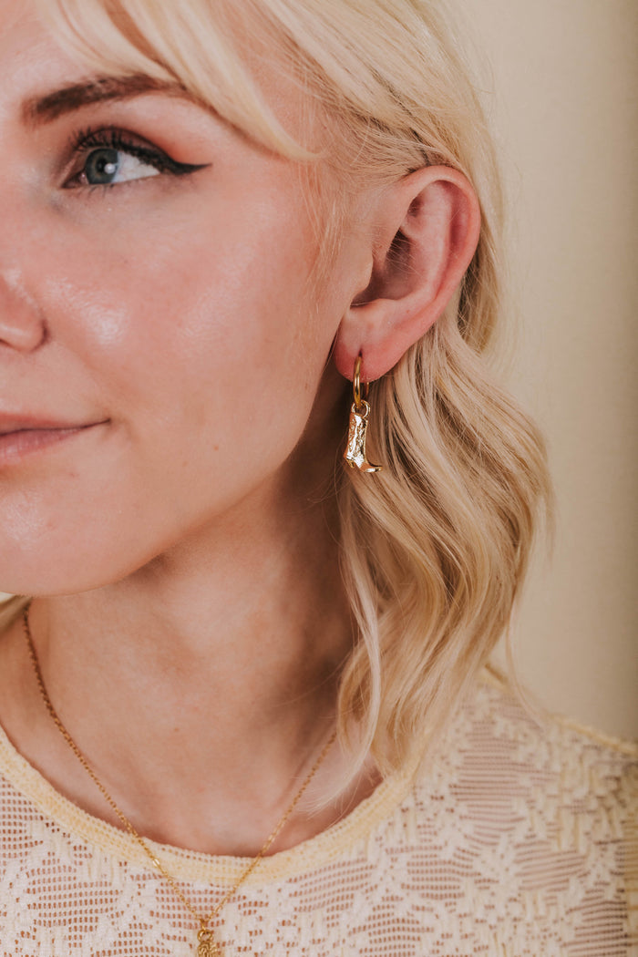 gold hoop huggie earrings with cowboy boot dangle
