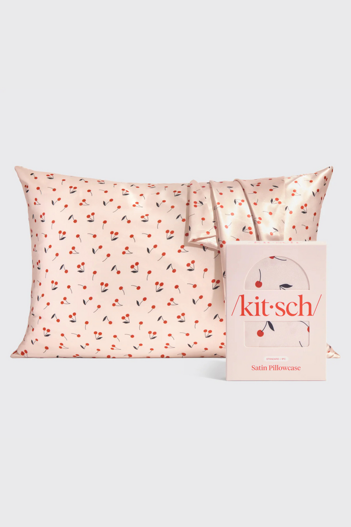 A KITSCH pink satin pillowcase with a cherry print pattern for better hair days