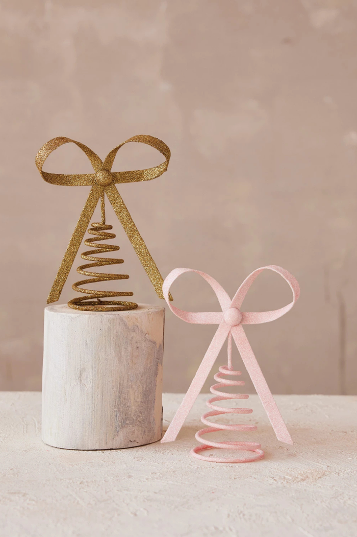 Decorative tree toppers in gold and pink glitter.