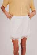 White satin mini skirt with lace trim and elastic in back of waistband