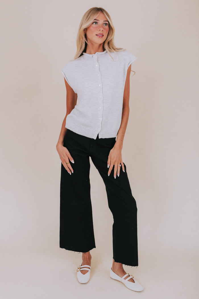 Soft knit shirt with cap sleeves/sleeveless and rolled edges. Button up front with ribbed hem.