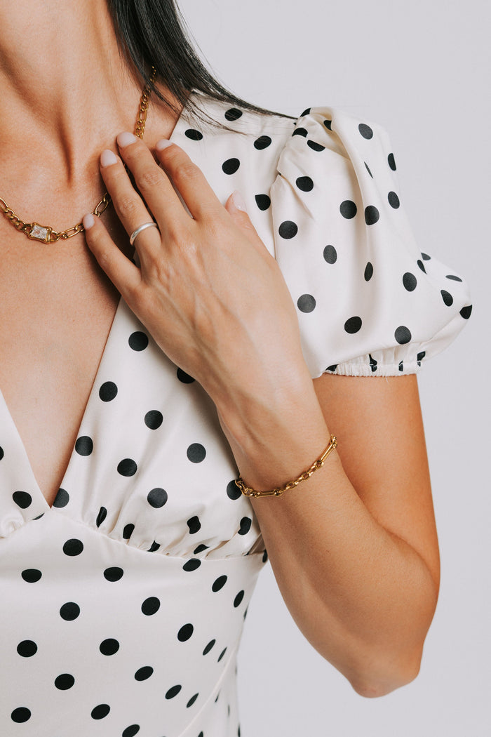 cream and black polka dot dress with v neck and puffed sleeves