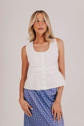 White sleeveless blouse with gathered lace, and pin-tucked details.