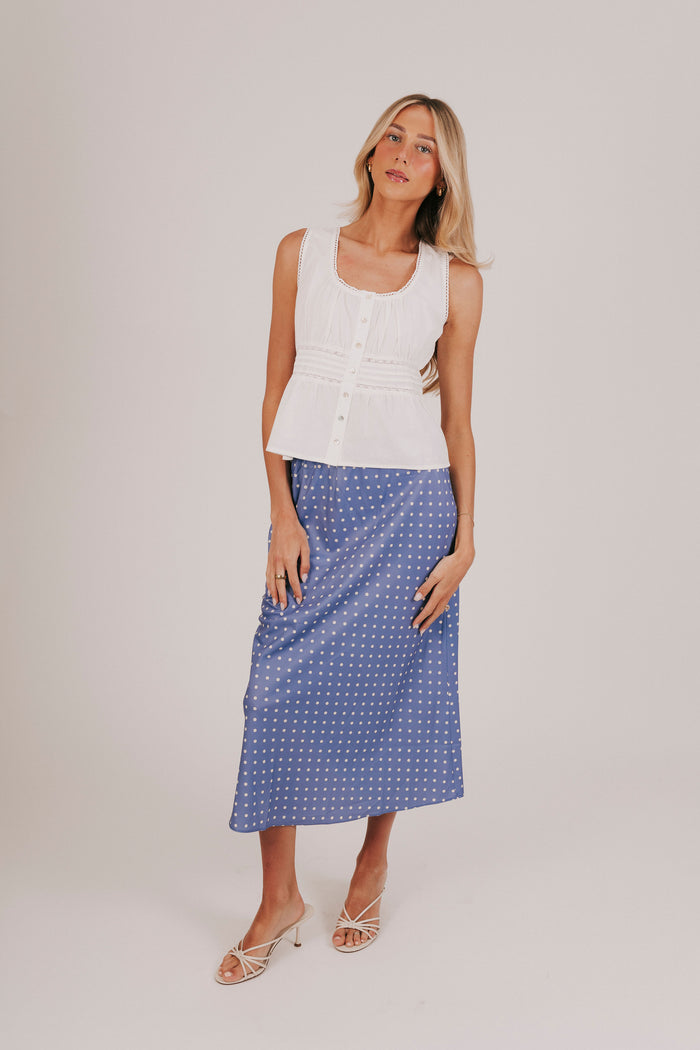 White sleeveless blouse with gathered lace, and pin-tucked details.
