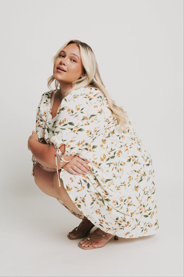 knee length floral dress with square neck and puff sleeves pose
