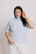 light blue top with textured pattern and mock neck