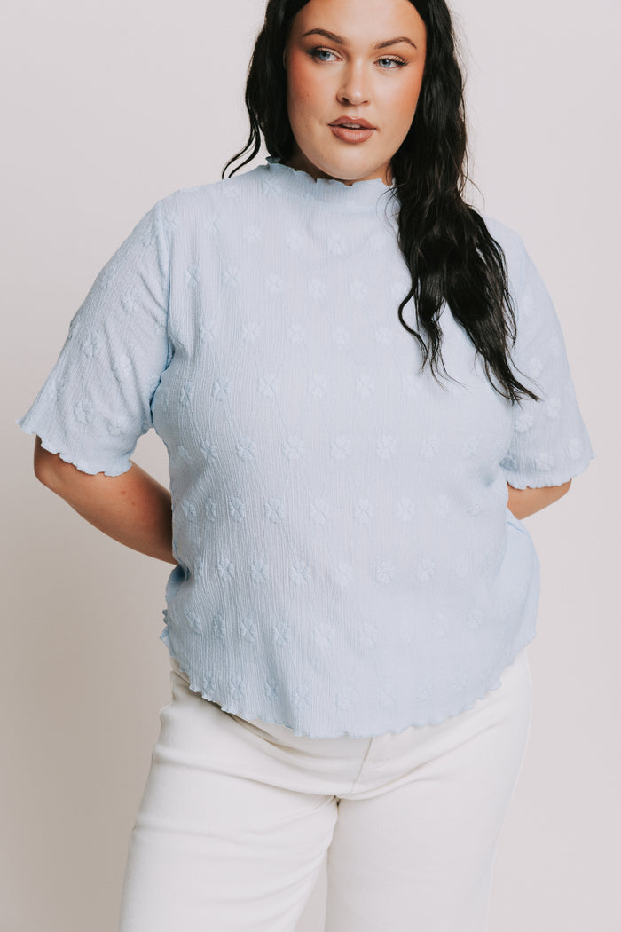 light blue top with textured pattern and mock neck close