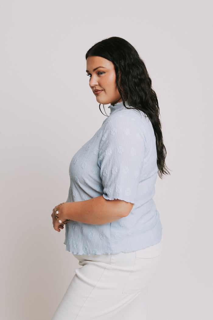 light blue top with textured pattern and mock neck side
