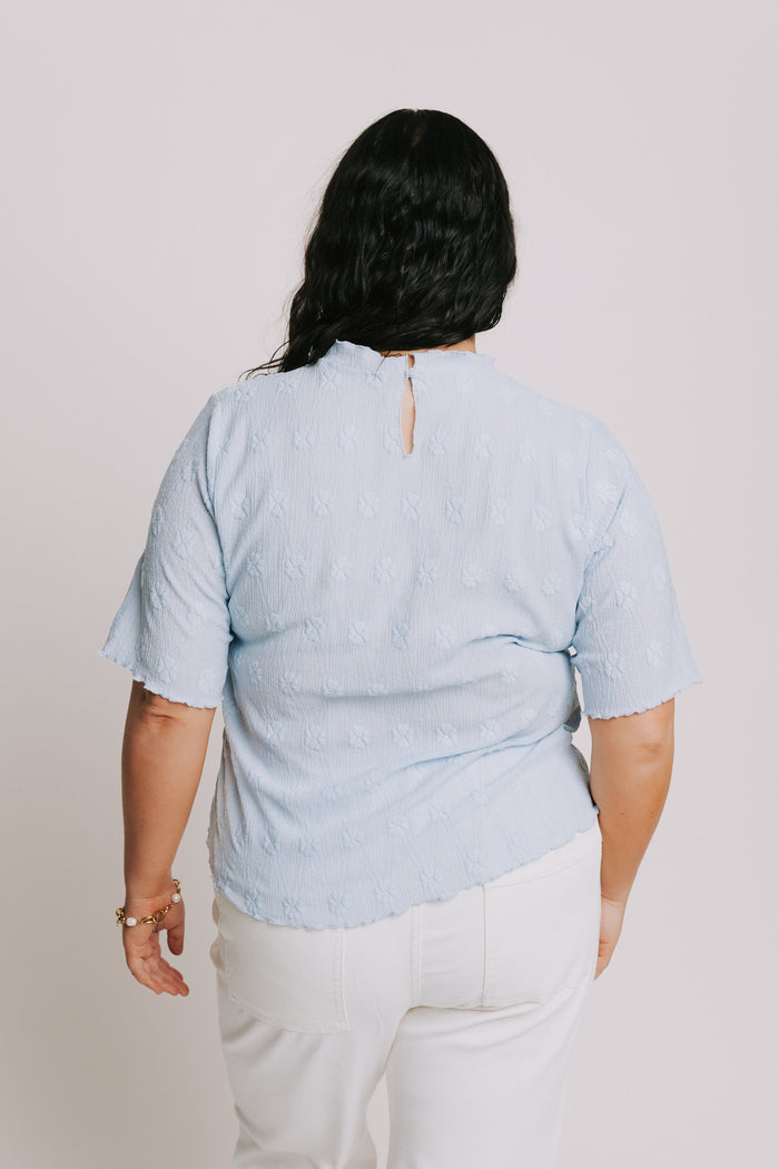 light blue top with textured pattern and mock neck back