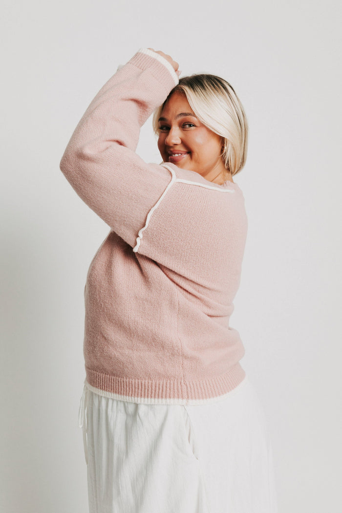 pink crewneck sweater with white trim side