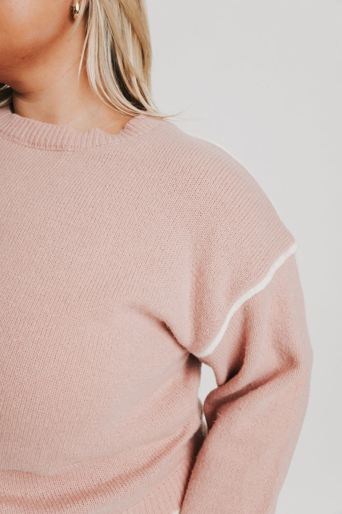 pink crewneck sweater with white trim detail