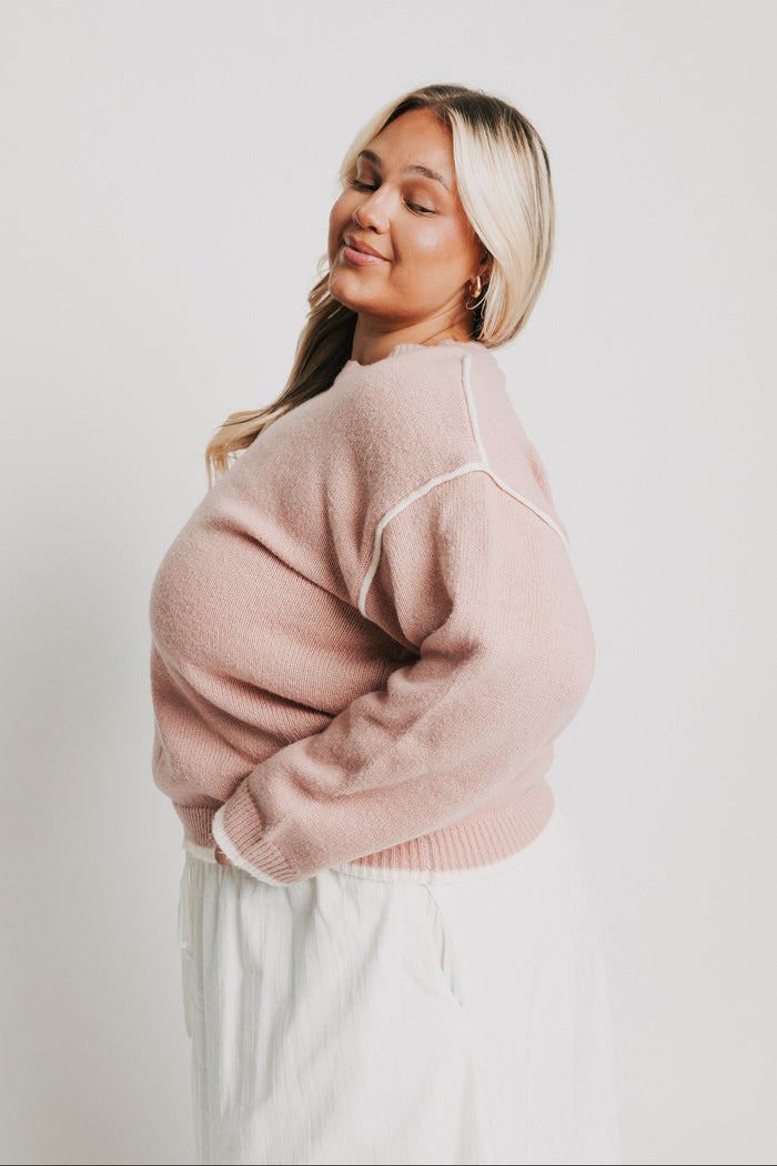 pink crewneck sweater with white trim side
