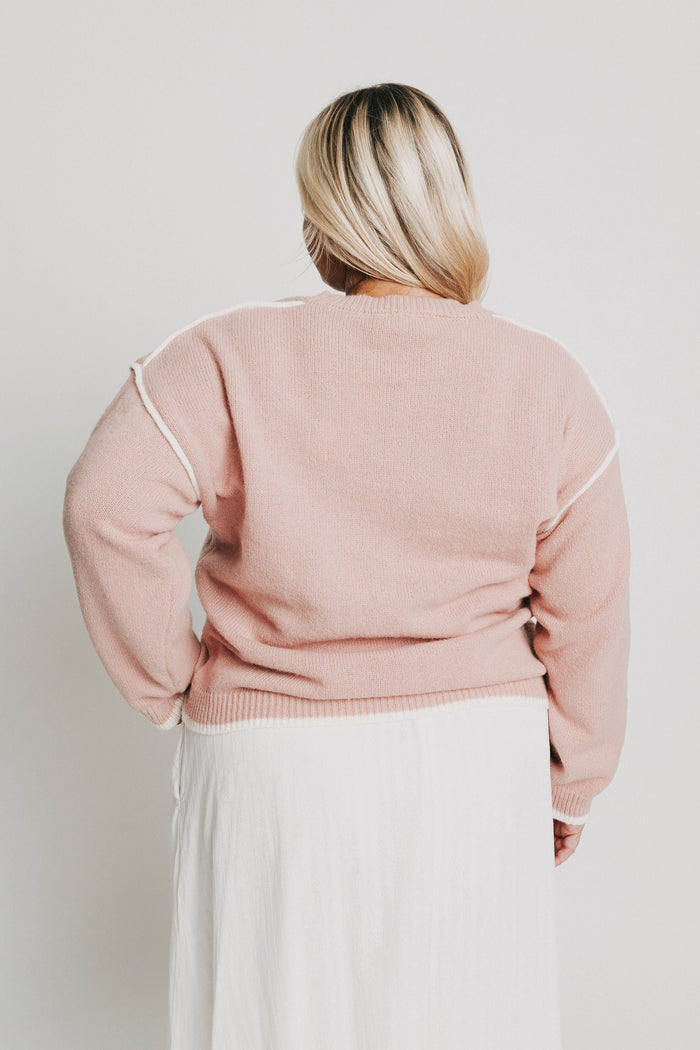 pink crewneck sweater with white trim back