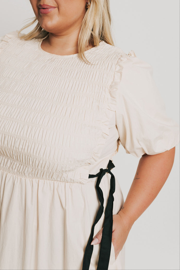 cream midi dress with black bow accents sleeves