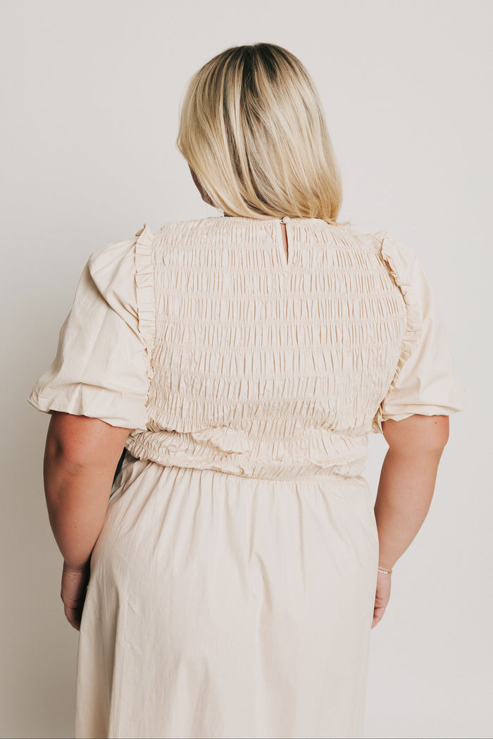 cream midi dress with black bow accents