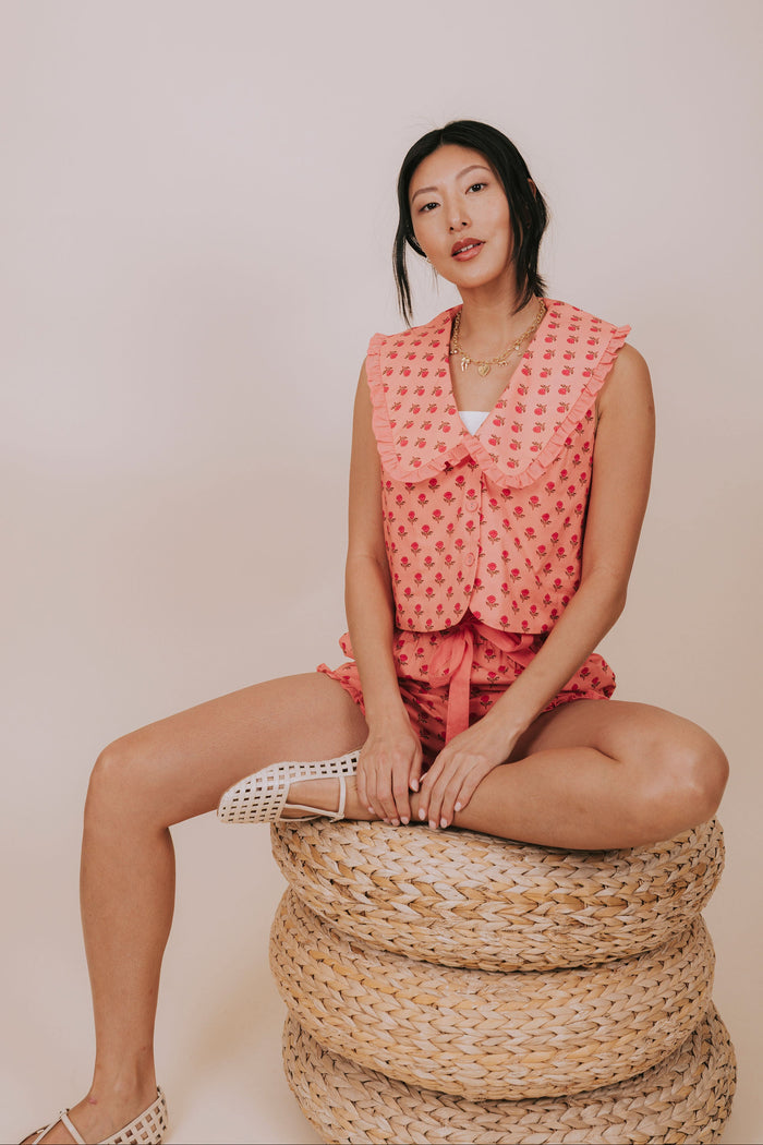 coral floral ruffled collared sleeveless top pose