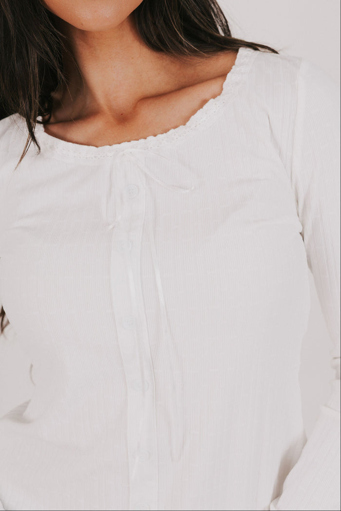 white long sleeve top with lace detail and bow