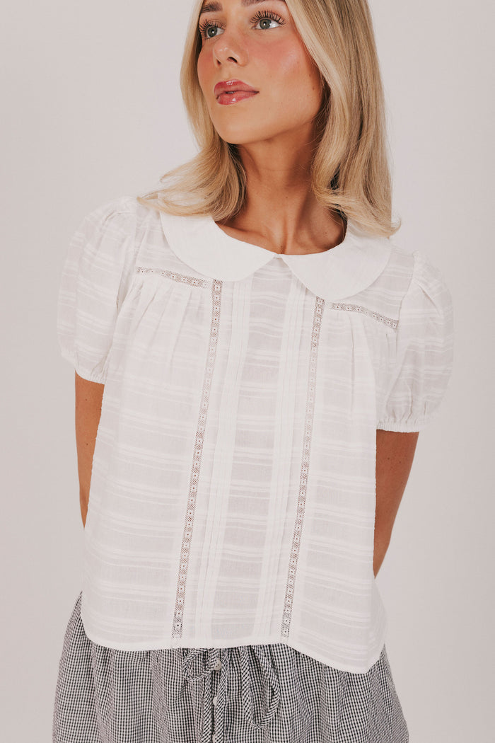 white textured top with a pan collar and short puff sleeves