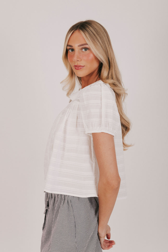 white textured top with a pan collar and short puff sleeves