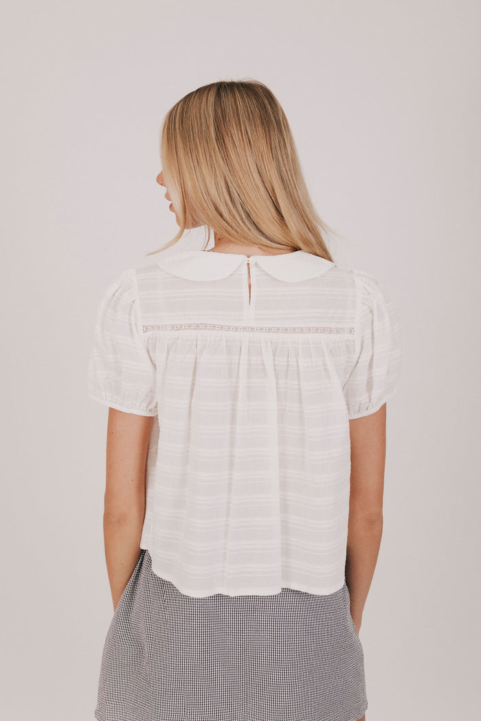 white textured top with a pan collar and short puff sleeves