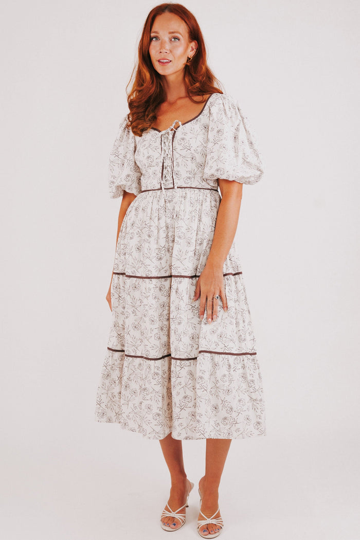 white tiered dress with brown floral pattern and puff sleeves
