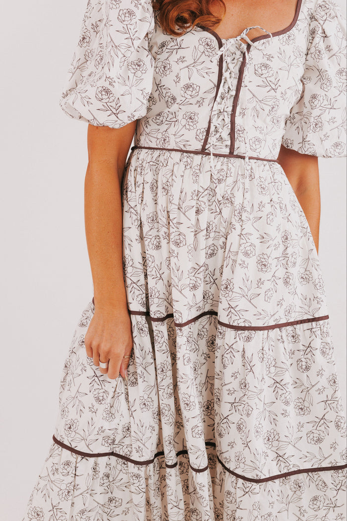 white tiered dress with brown floral pattern and puff sleeves