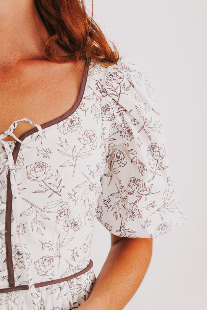white tiered dress with brown floral pattern and puff sleeves detail