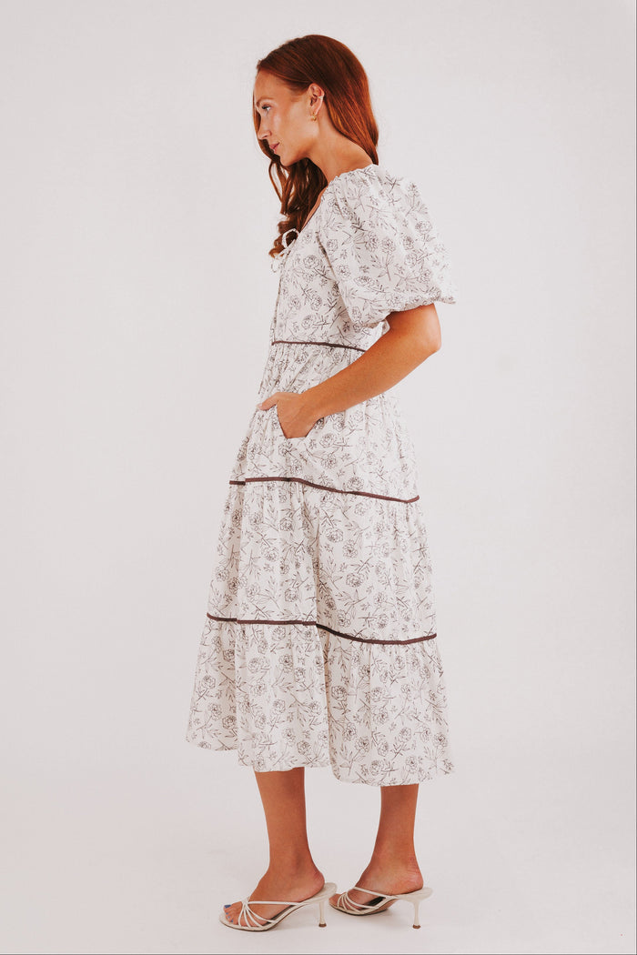 white tiered dress with brown floral pattern and puff sleeves side