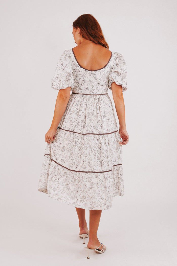 white tiered dress with brown floral pattern and puff sleeves back