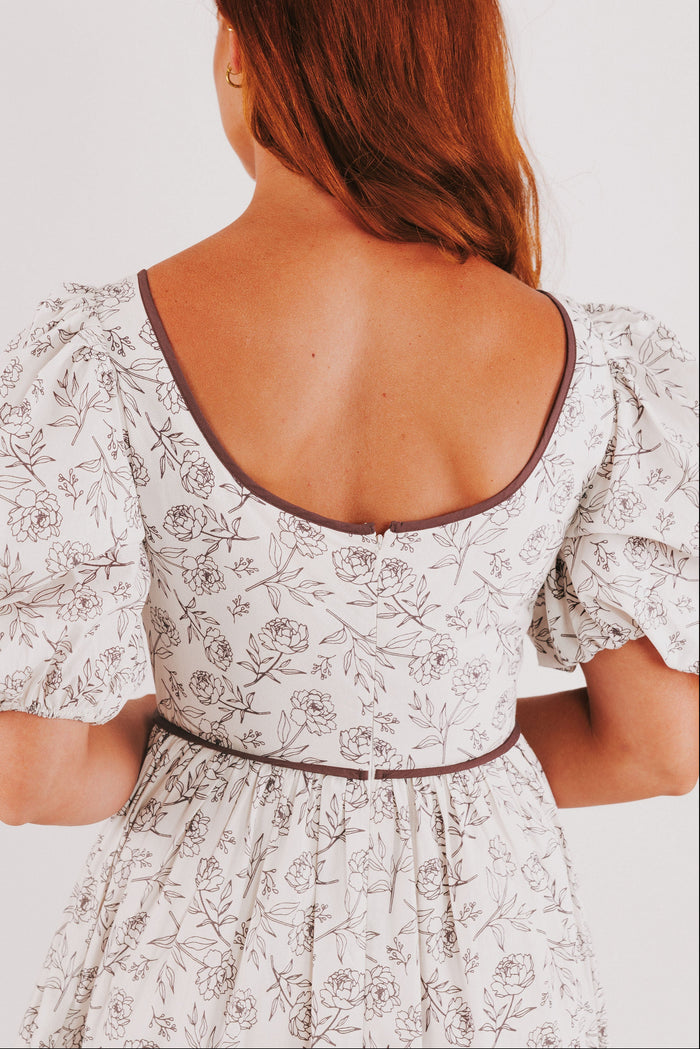 white tiered dress with brown floral pattern and puff sleeves back close