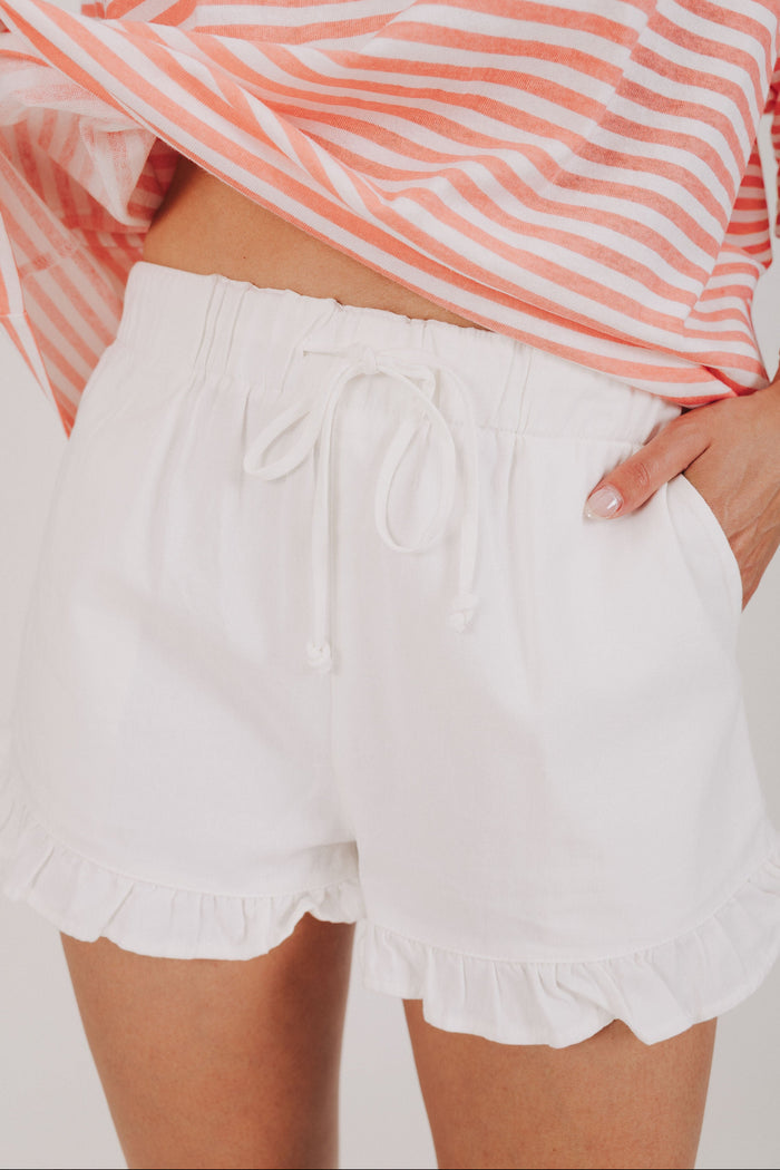 white cotton shorts with ruffled hem close