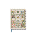 Softcover notebook with floral designs and a scalloped edge.