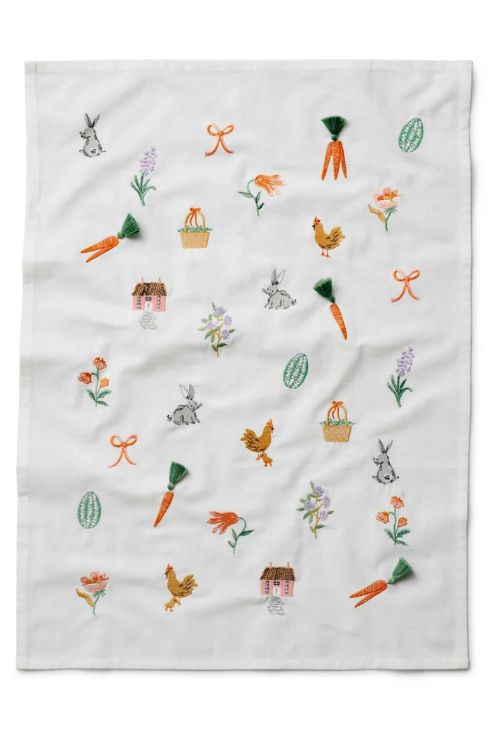Embroidered white hand towel with spring designs of bunnies, chickens, carrots, flowers, bows, eggs, and a cute cottage.
