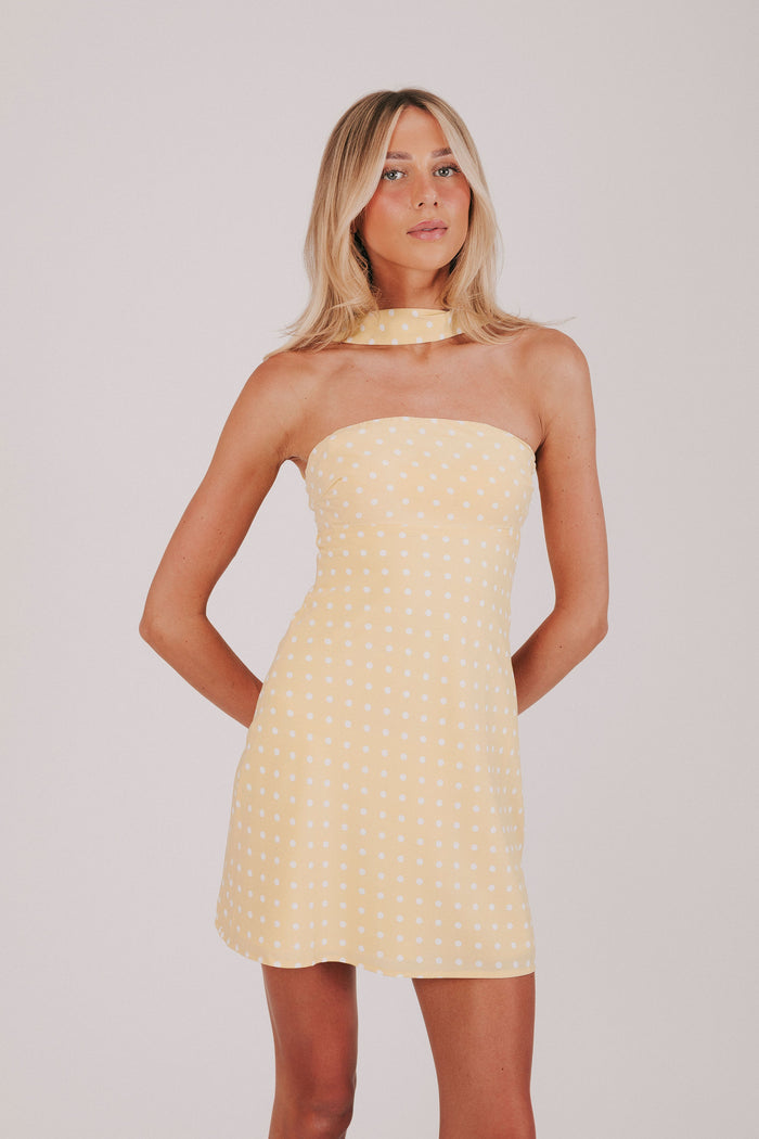 Yellow strapless dress with white polka dots and a scarf detail, mini length