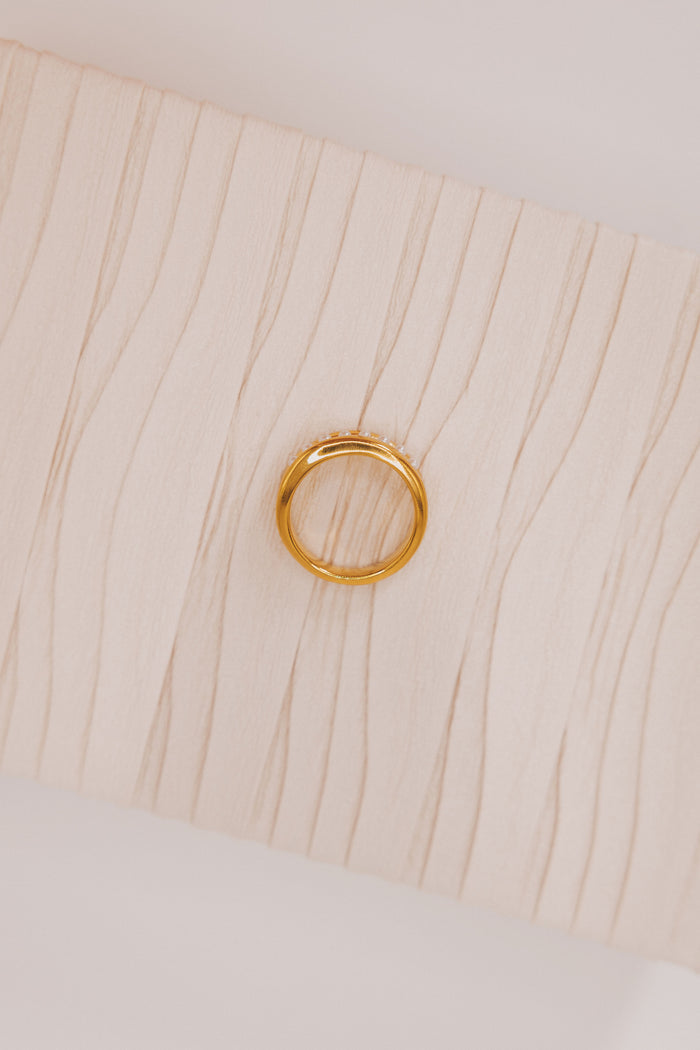 Gold ring with asymmetrical pearl line