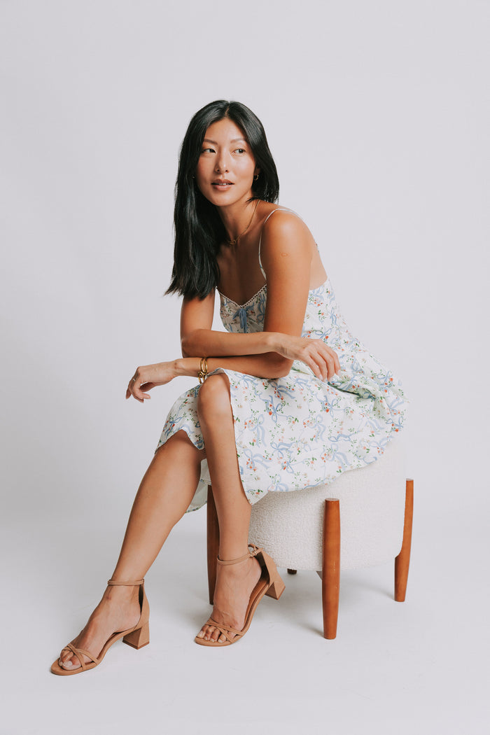 white spaghetti strap midi dress with blue bow pattern pose