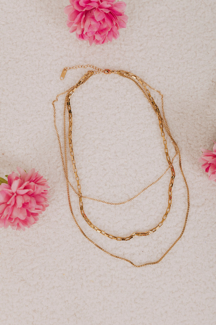 stainless steel gold colored necklace with three layers of box chains and an adjustable lobster clasp