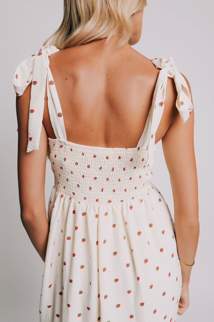 cream midi dress with strawberry print and bows on shoulders back close