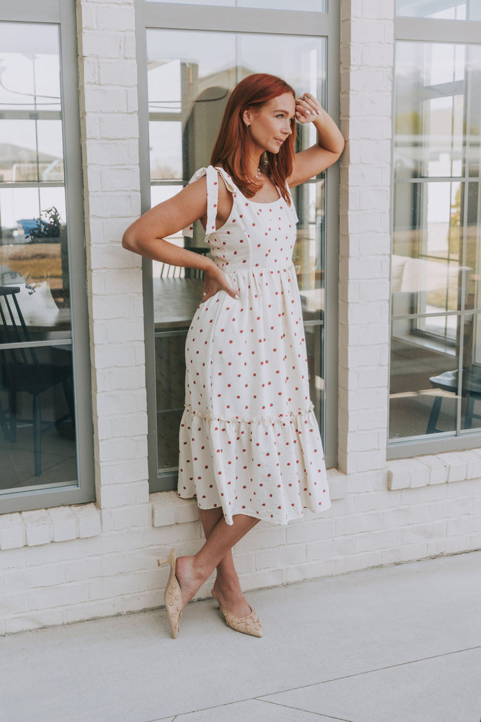 cream midi dress with strawberry print and bows on shoulders lifestyle