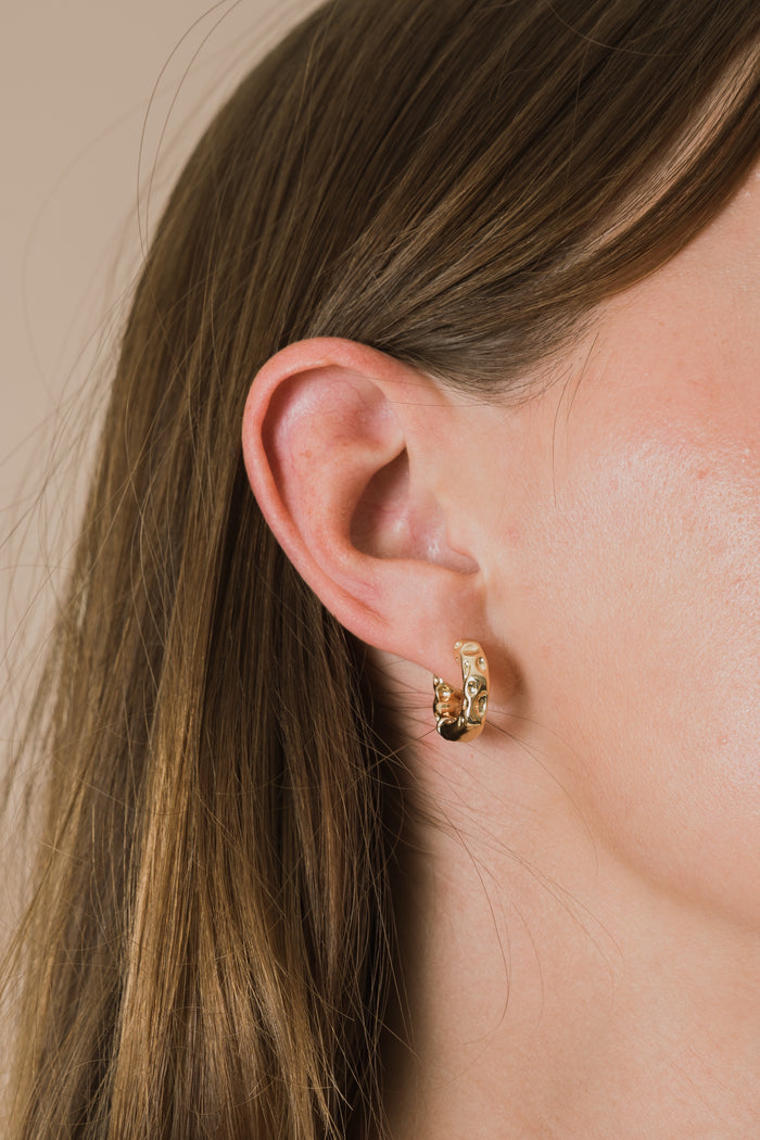 gold hoop earring with textured detailing and huggie closure