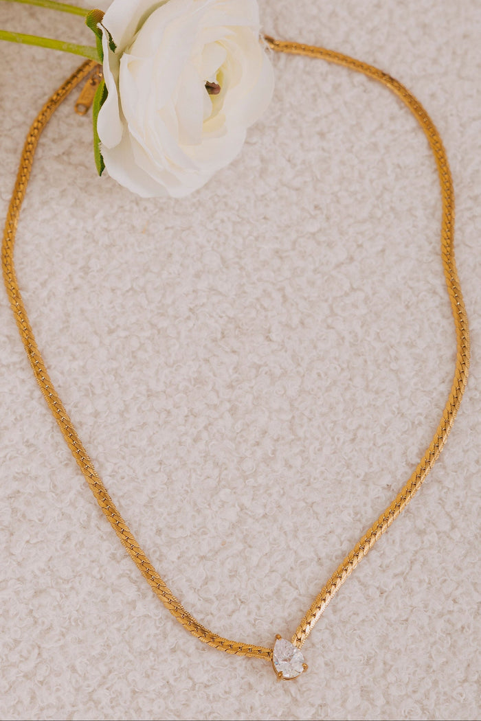 Gold necklace with a herringbone chain and cubic zirconia tear drop pendant