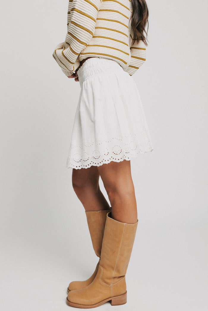 white mini skirt with eyelet on the hemline side
